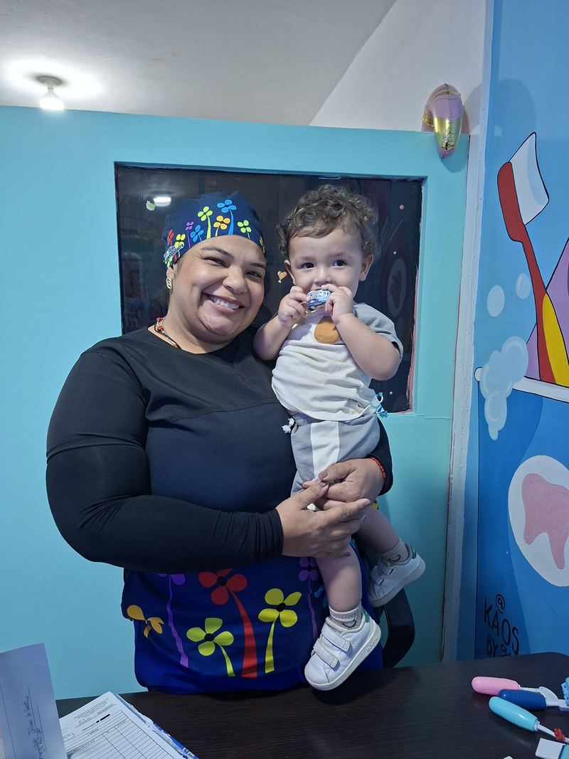 La Dra. Mine con un niño pequeño que sostiene un carrito de juguete